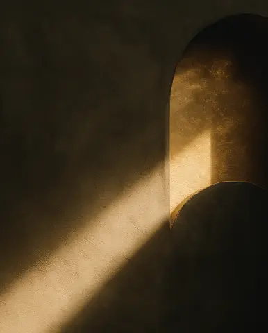 Soft sunlight casting an angled beam across a textured wall and partially illuminated plaster arch.